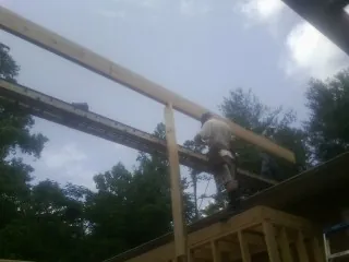 Carpenter setting a ridge beam over a new addition frame — Ice Dam Removal by Roofing Brothers in Honey Brook