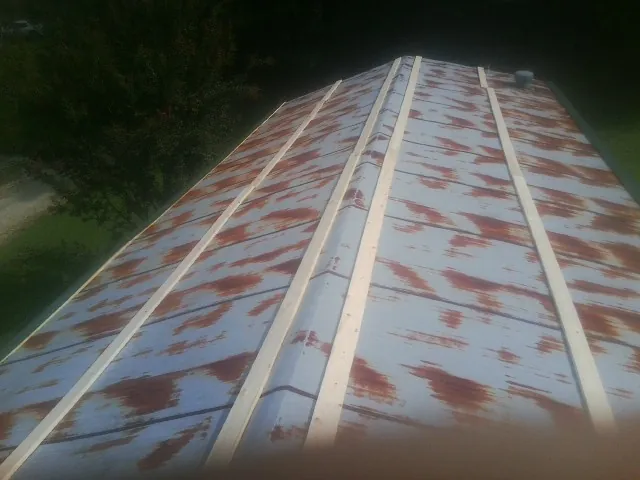 Rusted metal roof panels with new wood purlins before replacement — Storm Damage Roof Repair in Honey Brook by Roofing Brothers