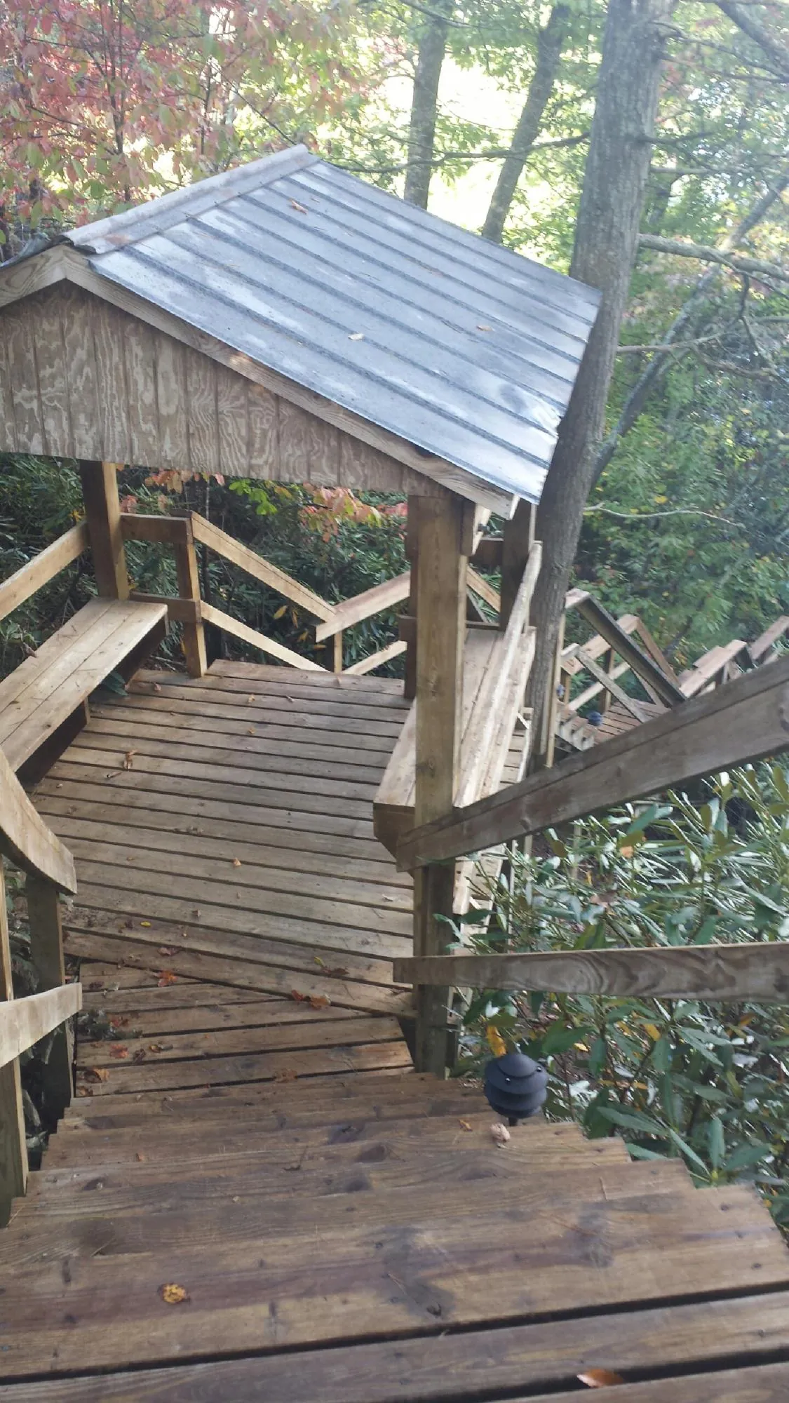 Metal roofed shelter over wooden steps on a wooded walkway — Skylight Repair & Installation work by our crew in Honey Brook