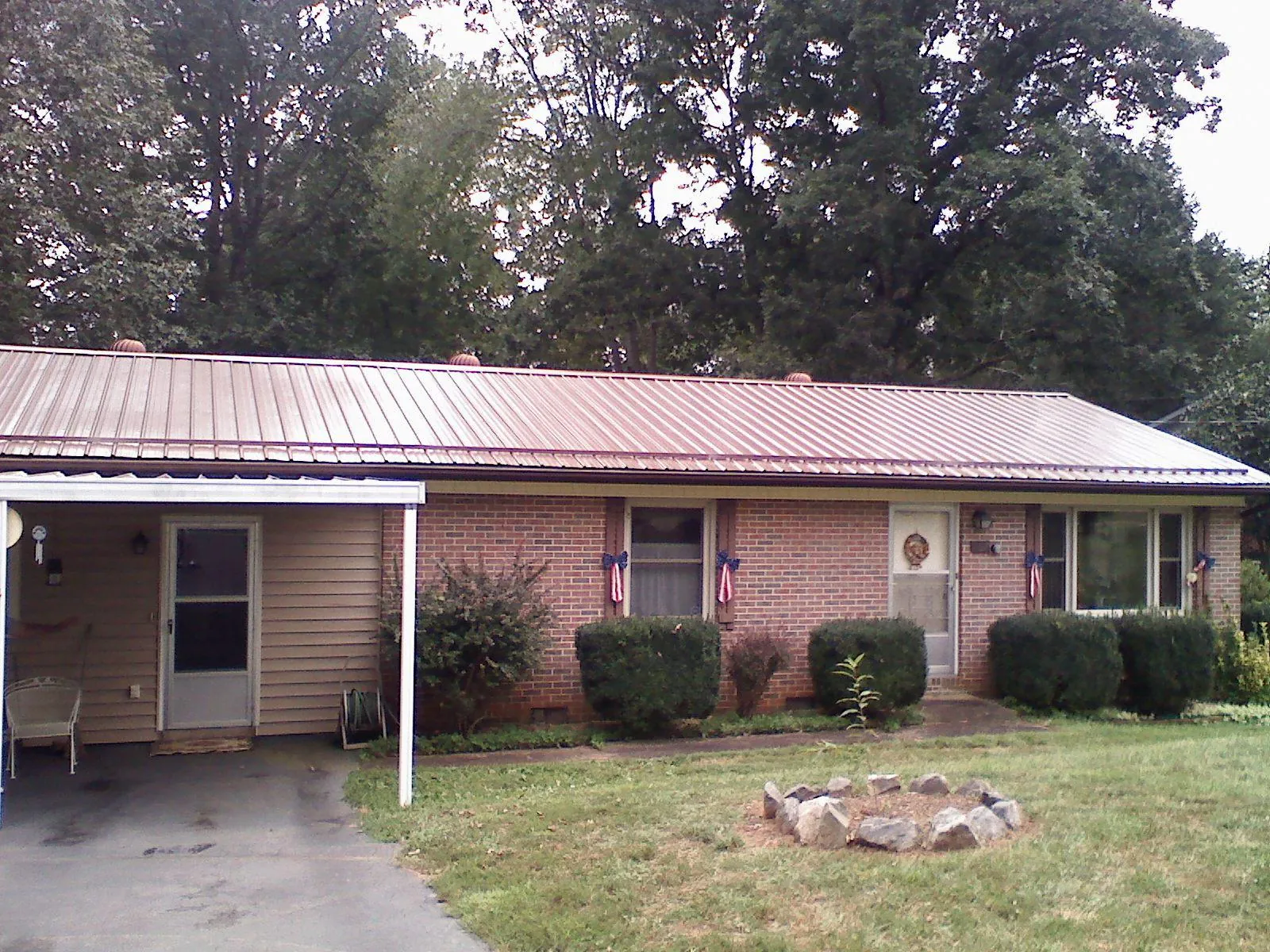 Bronze metal roof and carport on a brick ranch home — Roof Repair work by our crew in Honey Brook